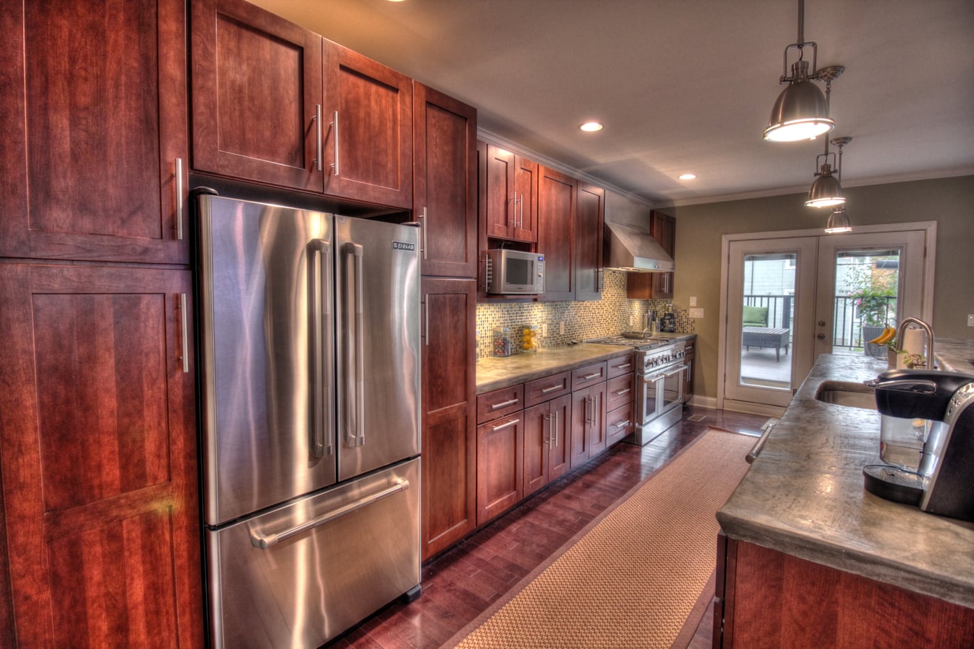 The finished kitchen, with a range and vent hood set into a tiled backsplash