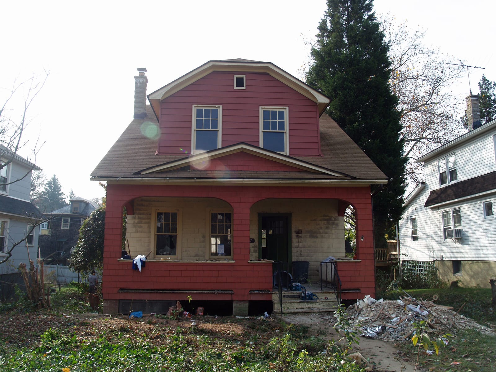The overgrowth cleared away, exposing the front porch and the original red cedar shingles