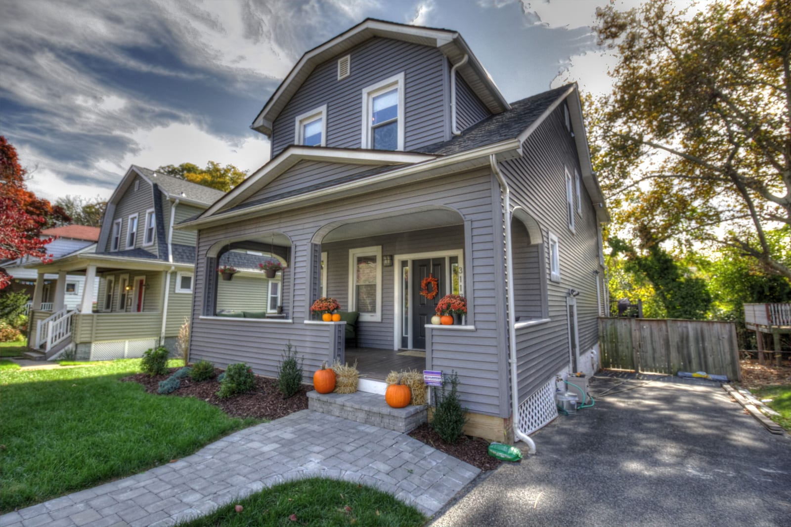 The finished home, with new siding, a paver walkway and a landscaped front yard